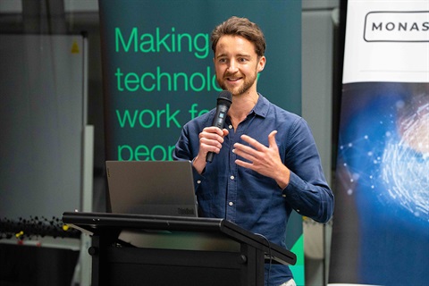 Young man holding a microphone giving a business presentation