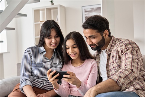 Family gathers to view phone indoors