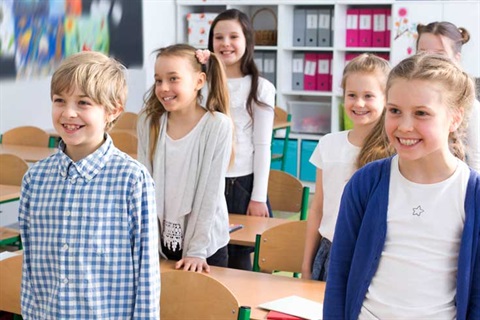 Children standing by school bench