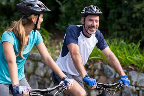 Biketober-smiling-couple-riding-bicycles-on-sunny-day-LEFT.jpg