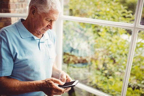Man next to the window using smartphone
