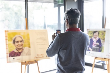 Audience member scanning the QR code on a Poetic Portraits display at launch