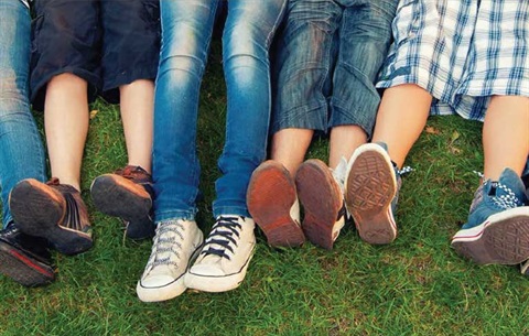 Teenagers laying in grass