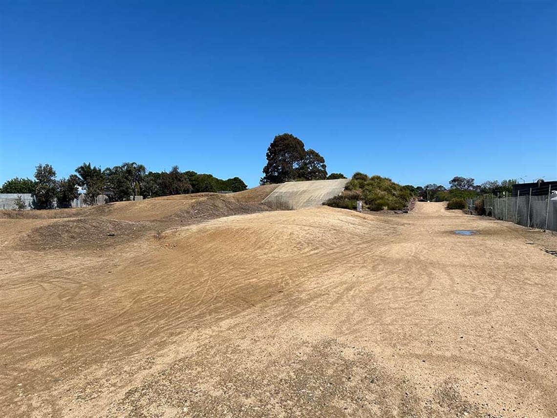 The dirt BMX track at Stan Riley Reserve in bright sunlight.