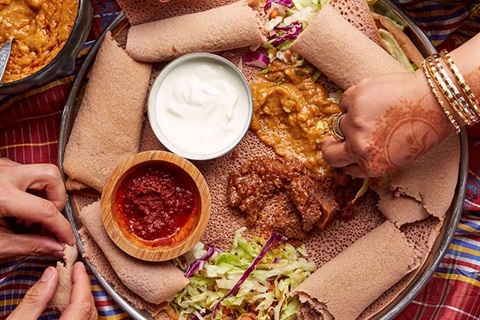 Hand reaching for eritrean food
