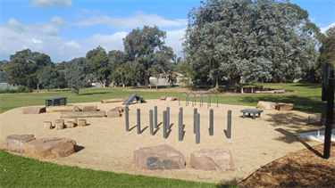 Dog off-leash area at Whitehaven Crescent Reserve in July 2026, with logs, agility hoops, boulders, ramp and more enrichment equipment