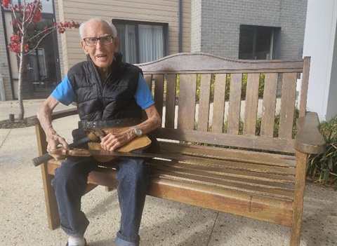 George Mulgrew, a carpenter on the original Glen Waverley library, sitting on a bench with his tools