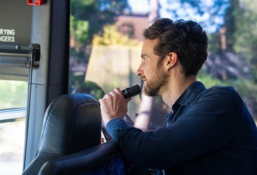 Start Up Invest and Grow - May 2025 - Investment Bus Tour - tour leader Desmond John speaking into a microphone on a bus