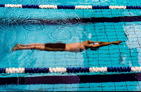 Young lifeguard standing in front of pool